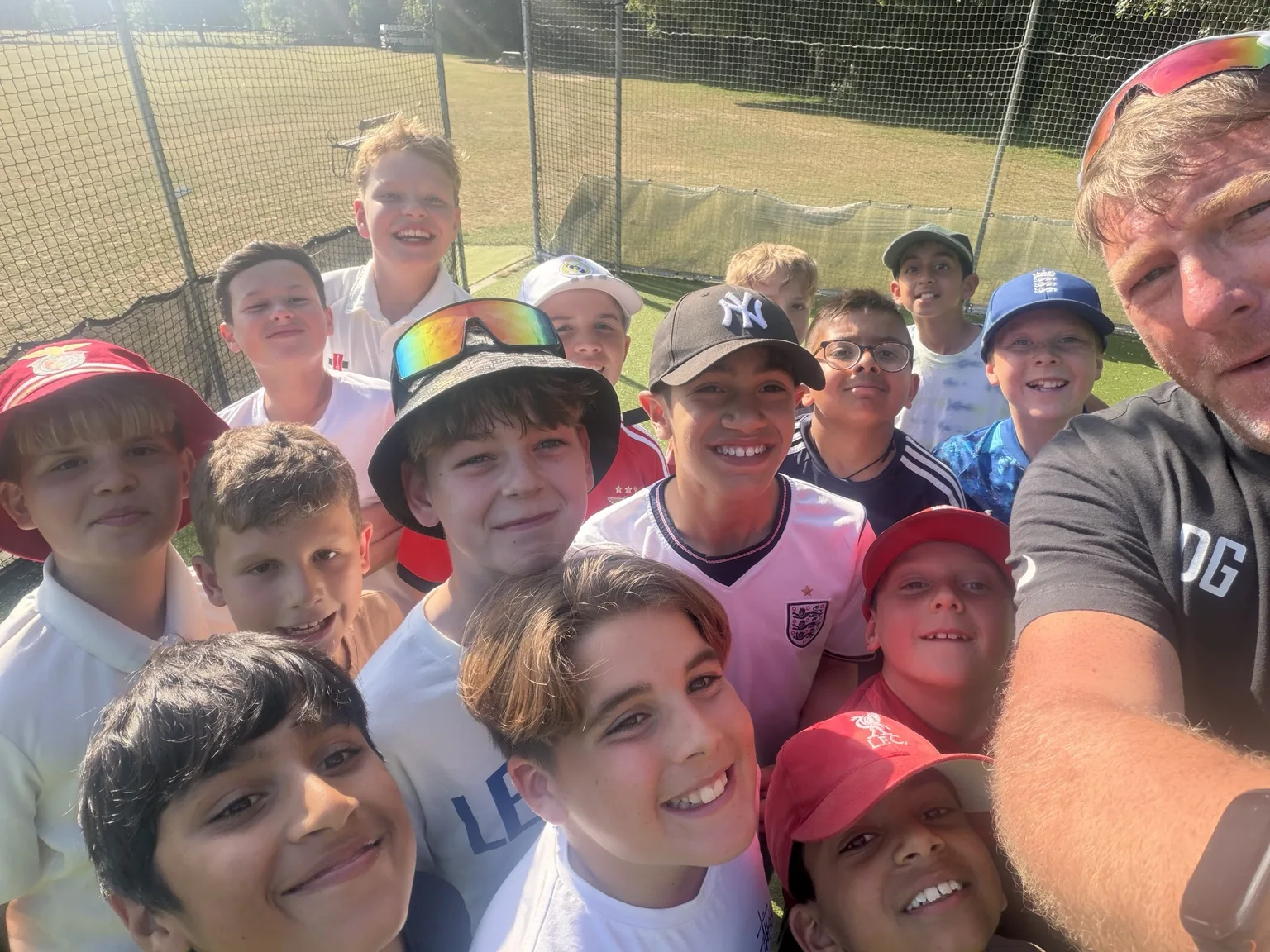 DG Cricket coach with a group of smiling young players