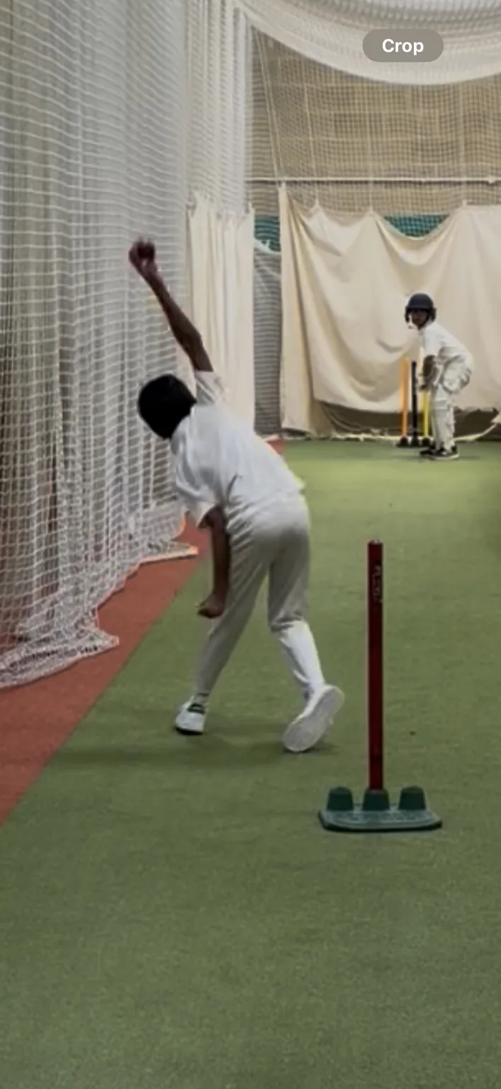 Indoor junior cricket coaching action