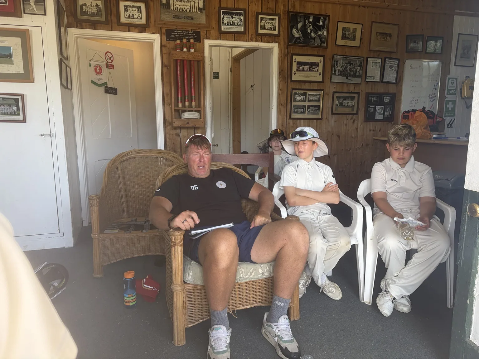 DG Cricket players with their coach in a pavilion